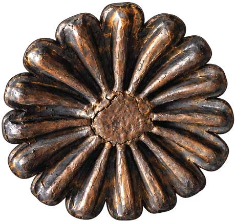 Detail of a dark ceramic seed pod with a radial, flower-like opening