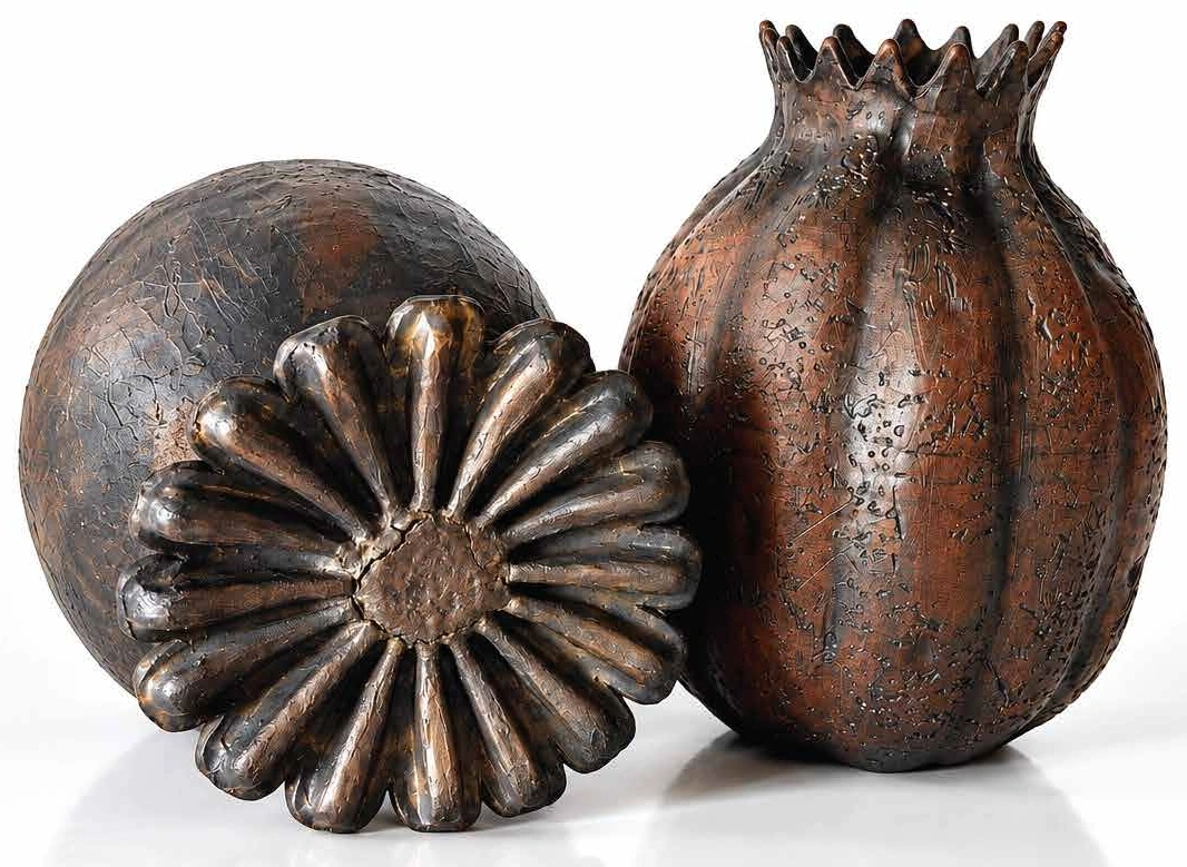 Two dark ceramic seed pods with textured earth-toned surfaces