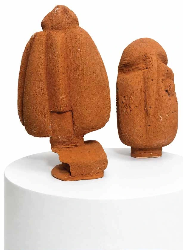 Two terracotta seed pod figures, one facing forward and one turned away